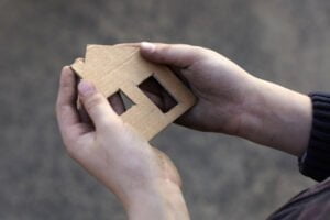 homeless boy holding a cardboard house